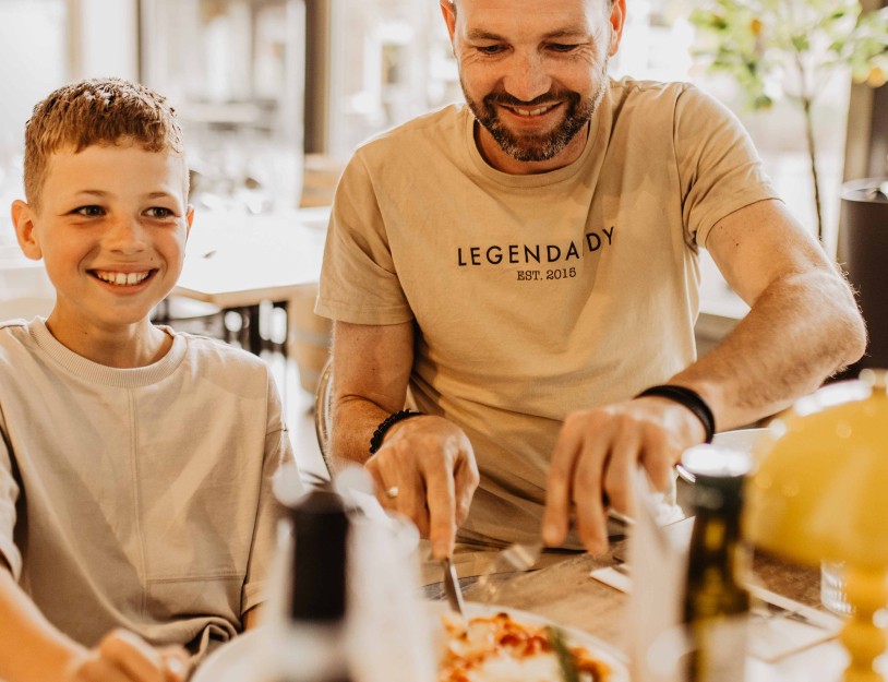 Camping-de-kleine-wolf-italiaan-pizza-snijden-lachen-papa-jongen.jpg
